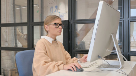Young Woman Using Desktop for Workの写真素材