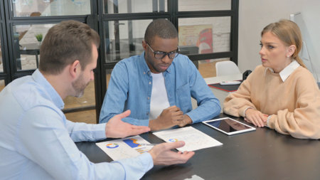 Entrepreneur in discussion with mixed race teammatesの写真素材