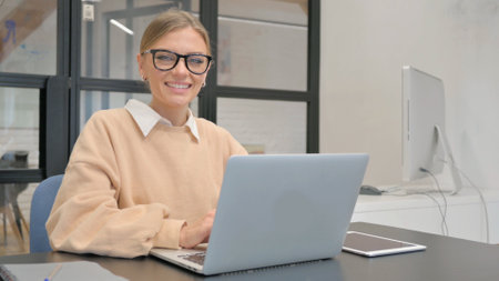 Female Worker Smiling at Camera in Officeの写真素材
