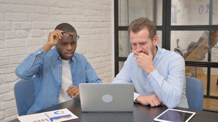 Mixed Race People Reacting to Loss in Officeの写真素材