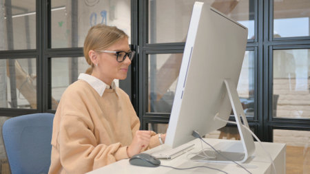 Woman in Glasses Doing Video Chat on Desktopの写真素材
