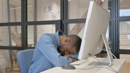 Man Sleeping while Working on Computerの写真素材