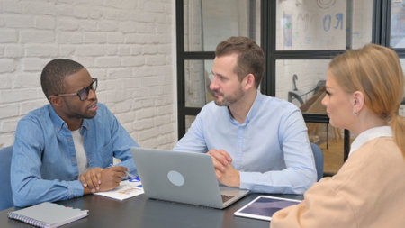 Mixed Race Entrepreneurs Discussing Business in Officeの写真素材