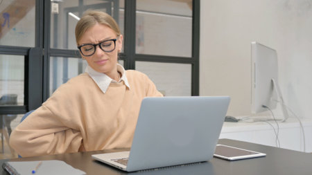 Female Worker having Back Pain in Officeの写真素材