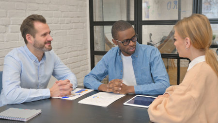 Mixed Race Entrepreneurs Discussing Work in Officeの写真素材