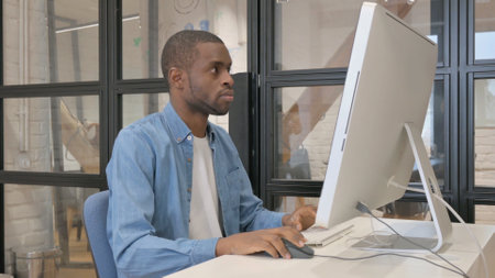 Casual African Man Using Computer for Workの写真素材