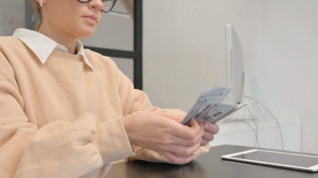 Close up of Female Hands Counting Money in Officeの写真素材