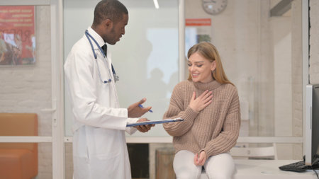 African Doctor Sharing Good News with Anxious Female Patientの写真素材