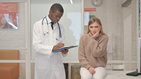 Woman with Toothache Consulting an African Dentistの写真素材