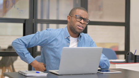 African Businessman having Back Pain in Officeの写真素材