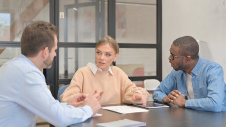Young Female Leader Talking with Multi Ethnic Teammatesの写真素材