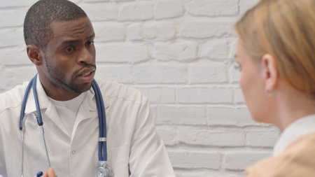 African Doctor Talking with Young Womanの写真素材