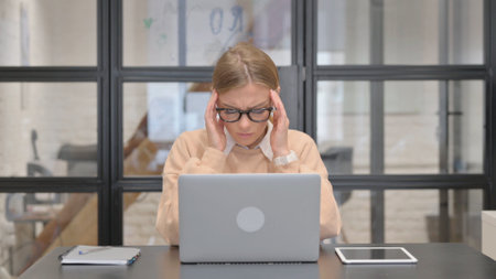 Young Woman having Headache at Workの写真素材