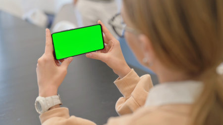 Woman Holding Phone Horizontal with Chroma Key Screenの写真素材