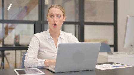 Shocked Mature Business Woman Looking at Camera in Officeの写真素材