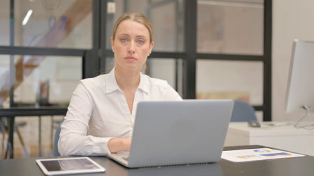 Mature Business Woman Looking at Camera in Officeの写真素材