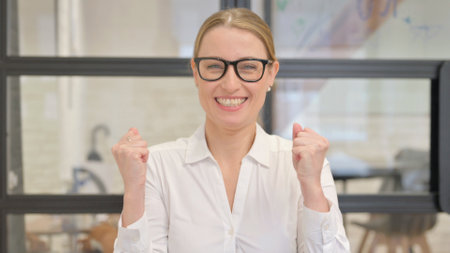 Portrait of Mature Business Woman Celebrating Success in Officeの写真素材