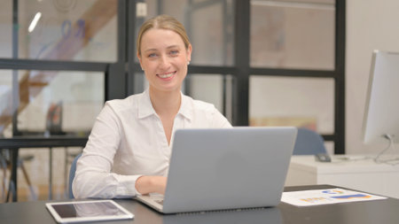 Mature Business Woman Smiling at Camera in Officeの写真素材