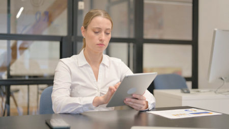 Mature Business Woman Using Digital Tablet in Officeの写真素材
