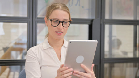 Portrait of Mature Business Woman Doing Video Chat on Tabletの写真素材