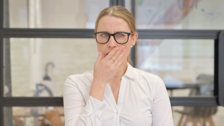 Portrait of Yawning Tired Mature Business Woman in Officeの写真素材