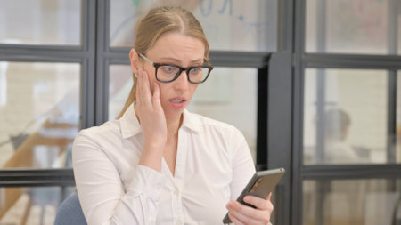 Portrait of Mature Business Woman Reacting to Loss on Phoneの写真素材