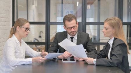 Business People Discussing Business Report in Meetingの写真素材
