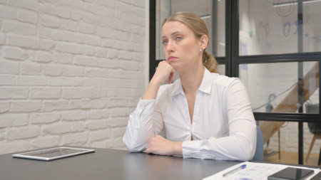 Pensive Mature Business Woman Sitting in Officeの写真素材