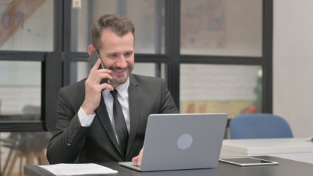 Businessman Talking on Phone, Discussing Projectの写真素材
