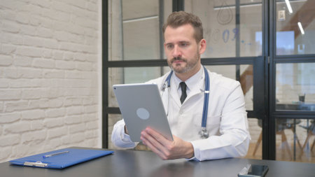 Middle Aged Doctor Using Digital Tablet for Workの写真素材