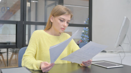 Young Blonde Woman Reading Documents at Work