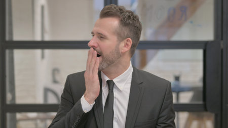 Portrait of Yawning Tired Middle Aged Businessmanの写真素材