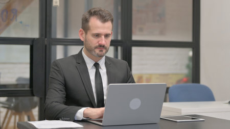 Businessman Working on Laptop, Typing Emailの写真素材