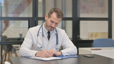 Middle Aged Doctor Writing a Document, Medical Reportの写真素材