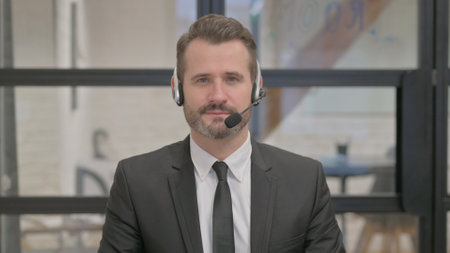 Portrait of Serious Call Center Employee with Headsetの写真素材