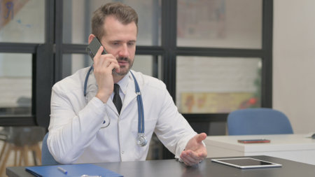 Middle Aged Doctor Talking on Phoneの写真素材