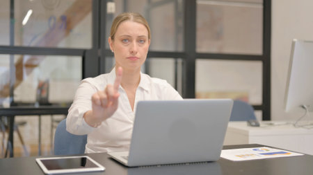 Mature Business Woman Rejecting while Using Laptop in Officeの写真素材