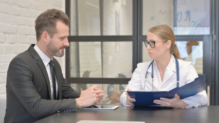 Female Doctor Talking with Young Manの写真素材