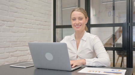 Mature Business Woman Smiling at Camera in Officeの写真素材