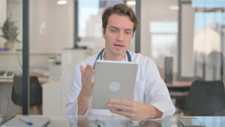 Male Doctor Doing Video Chat on Tabletの写真素材