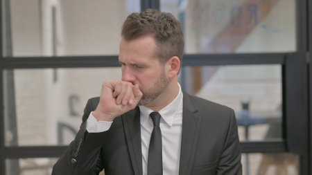Portrait of Coughing Sick Middle Aged Businessmanの写真素材
