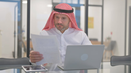Arab Man Working on Documents in Officeの写真素材