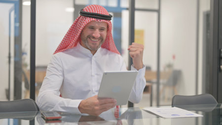 Arab Man Celebrating while Using Tabletの写真素材
