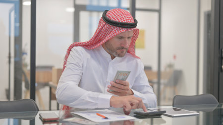 Arab Man Doing Financial Calculations, Counting Moneyの写真素材