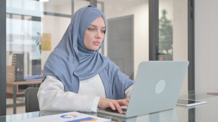 Woman in Hijab Working on Laptopの写真素材