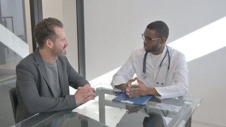 Doctor Talking with Middle Aged Man in Clinicの写真素材