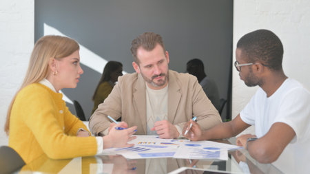 Young Mixed Race People Doing Paperwork in Officeの写真素材