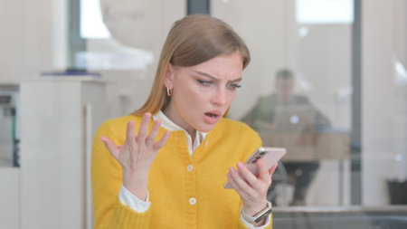 Portrait of Young Woman Shocked by Loss on Phoneの写真素材