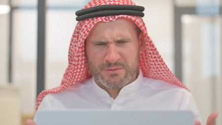 Close up of Arab Man Shocked by Loss on Laptopの写真素材