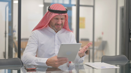 Arab Man Reacting to Money Loss on Tabletの写真素材